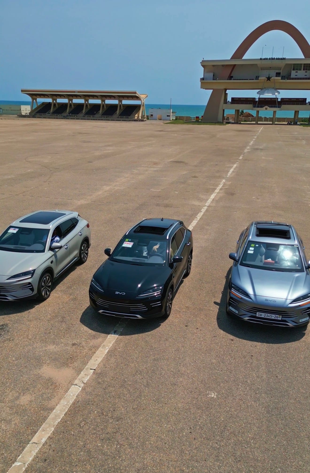 Transparent Rentals fleet of three 2025 BYD Song Plus SUVs parked at Black Star Square in Accra, Ghana — silver, black, and grey vehicles ready for chauffeur-driven car hire with a professional driver